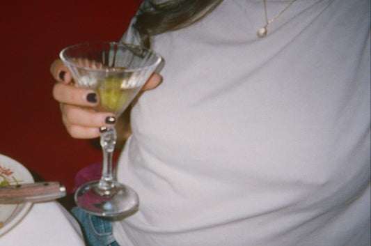 girl in white tee shirt holding a martini is wearing nikkys nips fake nipple piercings