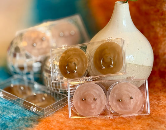 image showing collection of nikkys nips nipple pasties over a blue and orange background.
