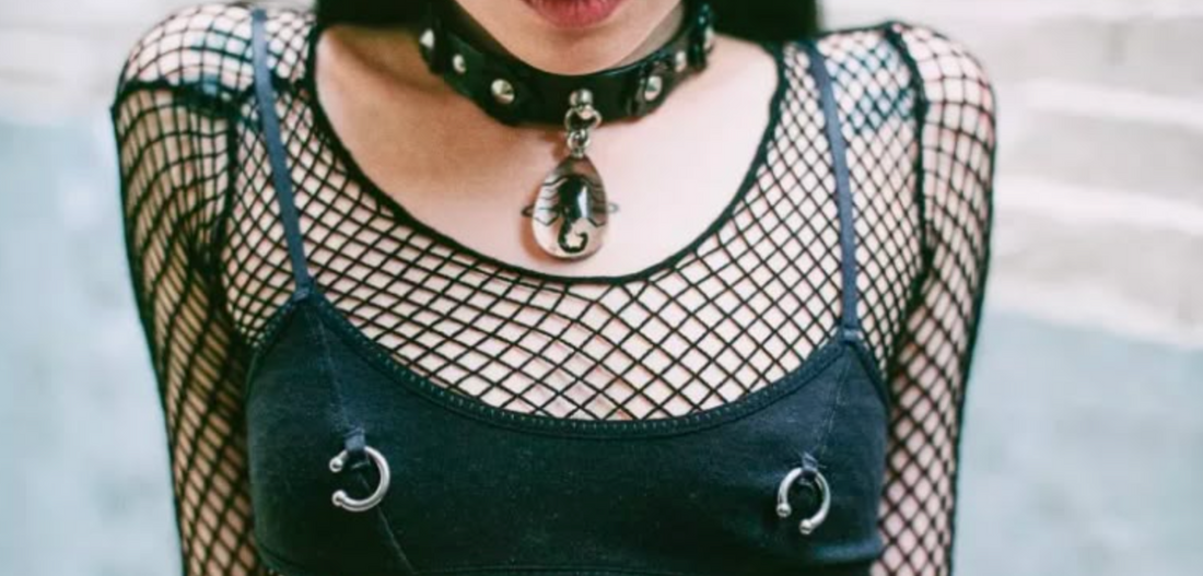 woman wearing a black mesh top with a piercing trend accessory