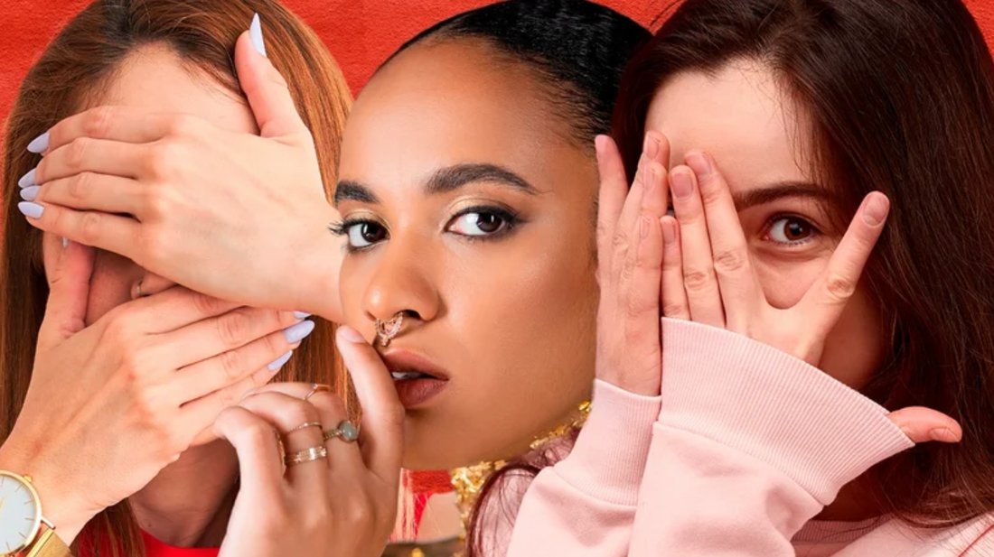 Three women: a central figure with a nose ring puts a finger to her lips, while two others cover their eyes, evoking themes of subtle secrets and personal style