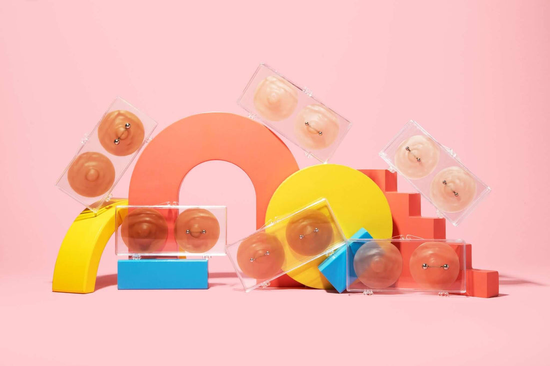 photo showing the collection of nikkys nips fake nipple piercings over a pink background